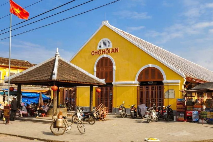 Hoi An market on the Thu Bon River with locals buying and selling fresh food.