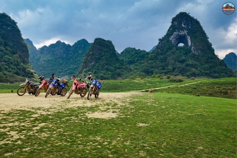 High-clearance multi-terrain motorcycles parked along a scenic viewpoint.